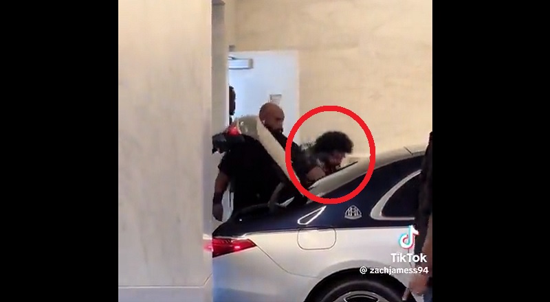 Drake tries to hide from paparazzi as he gets into car
