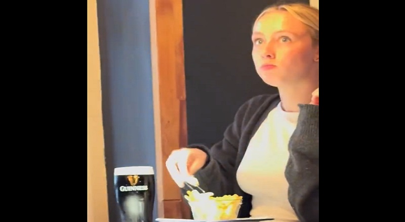 Woman nervously eats French fries in a restaurant